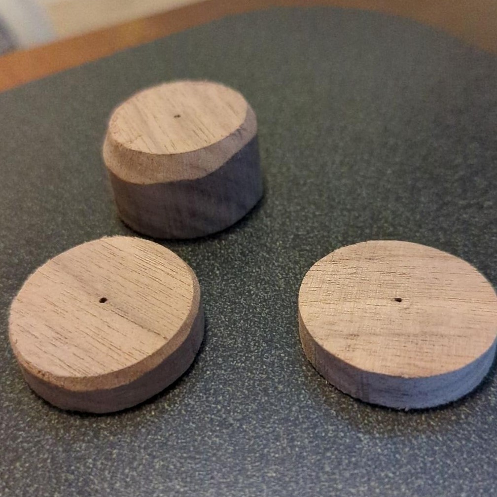 3 walnut wood disks on a desk